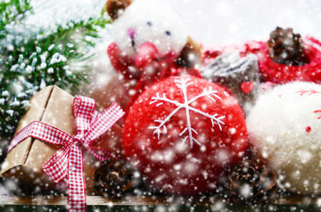 Set of christmas toys - balls, snowman, gift box with red ribbon and bow and pine tree twigs and snowの写真素材