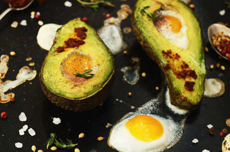 Baked avocado with quail eggs, black salt and pepper