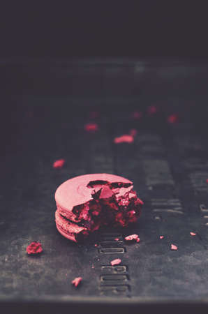 Single macaroon cookie on metal tray with copyspace on dark backgroundの写真素材