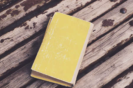 Yellow retro book on wooden rusted backgroundの写真素材