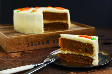 Slice of homemade carrot cake with empty space on dark backgroundの写真素材
