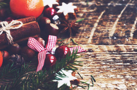 Winter decoration with festive balls with ribbon and bow and xmas fir tree with copy space on rustic wooden backgroundの写真素材