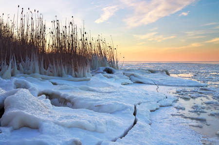Winter landscape with frozen lake and sunset sky. Composition of nature.の写真素材