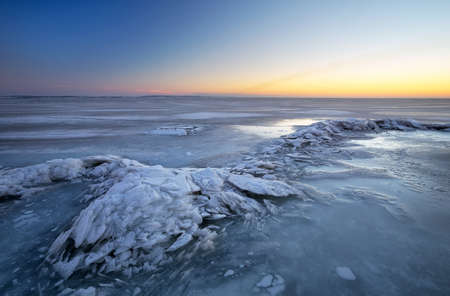 Winter landscape with lake and sunset fiery sky. Composition of nature.の写真素材