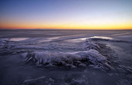 Winter landscape with lake and sunset fiery sky. Composition of nature.の写真素材