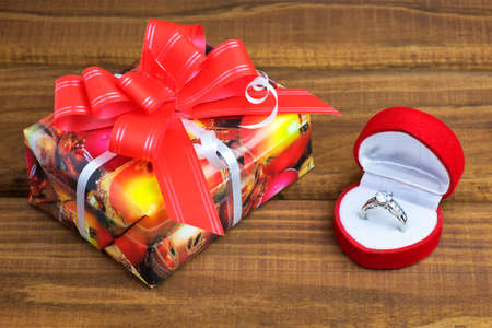 A little present box and box with ring on wooden tableの写真素材