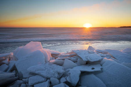 Winter landscape with frozen lake and sunset sky. Composition of nature.の写真素材