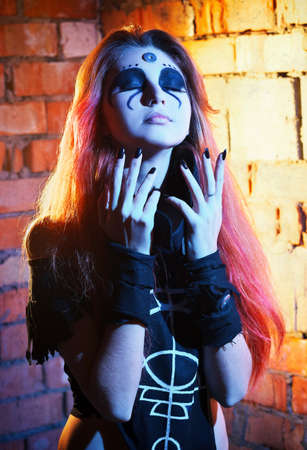 Portrait of scary girl with white eyes for Halloween. Scary witch in the cave.