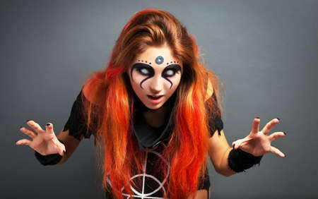 Portrait of scary young girl with white eyes for Halloween on gray background