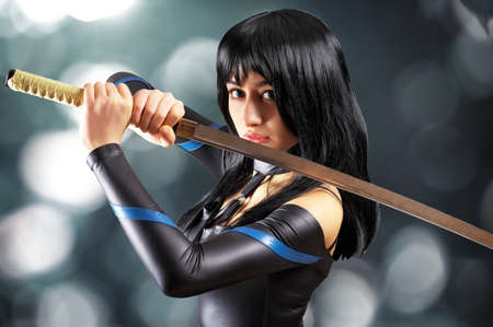 Beautiful girl with sword on bokeh backgroundの写真素材