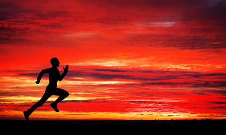 Silhouette of running man on sunset fiery background