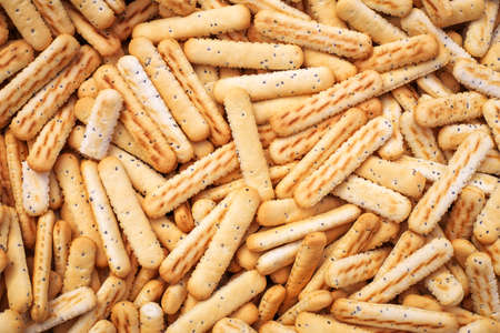Bread sticks with poppy seeds as background