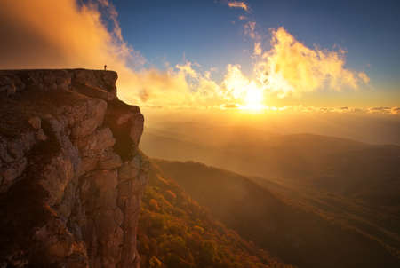 Beautiful mountain landscape with sunset sky in autumn time. Photographer takes pictures on top of the mountain の写真素材