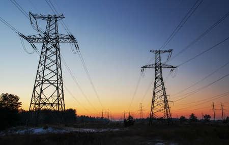 High-voltage power lines during fiery sunrise