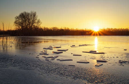 Winter landscape with sunset sky and frozen river. Daybreakの写真素材