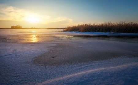Winter landscape with river and sunset sky. Composition of nature.の写真素材