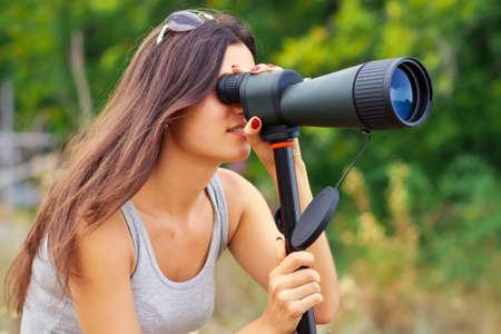 Positive girl watching in Spyglass while walking