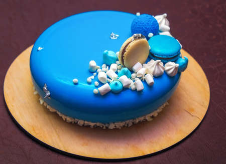 Tasty blue cake with a macarons and marshmallow.の写真素材