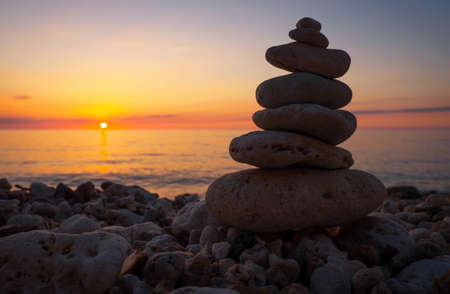 Pyramid of the small pebbles on the beach. Stones, against the background of the sea shore during...