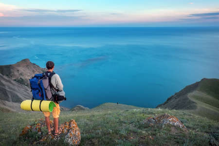 Young tourist on top of a mountain enjoying sea view.の写真素材