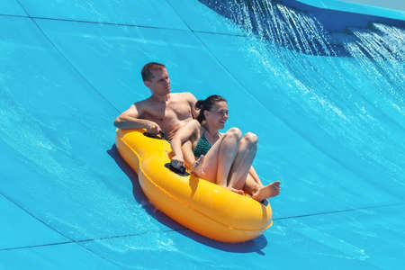 Two people in a water slider at the beach の写真素材