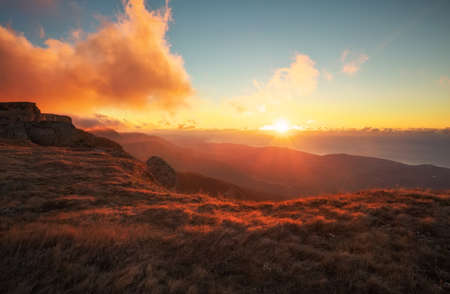 Red and orange sunset in the mountains in autumn time. Landscape with sunny beams. Dramatic scene. In the background view of the sea
の写真素材