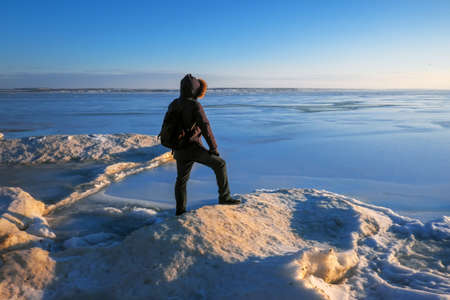 Man on the frozen river during sunset. の写真素材