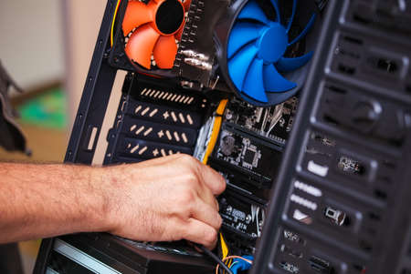 Computer technician installs cooling system of computer. Assembling PC