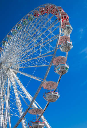Ferris wheel on blue sky background. In the amusement Park. The weekend