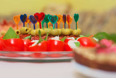 Canape on skewers with cheese, sausage and olives, tomato and on a buffet for a party or wedding, cateringの写真素材