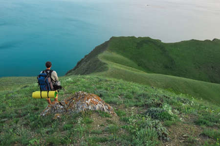 Young tourist on top of a mountain enjoying sea view.