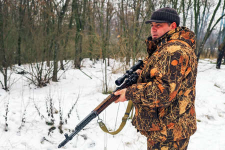 Winter hunting. Hunter moving With rifle and Looking For Prey.