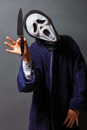 The man in white mask threatens with knife, killer concept, horror theme , Halloween conceptsの写真素材