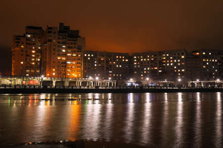 City embankment at night. Lights in the windows of apartments and lanterns. Winter is coming.の写真素材