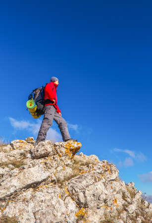 Photographer on top of the mountain in autumn. Traveler with backpack enjoying a view from the mountain top

の写真素材