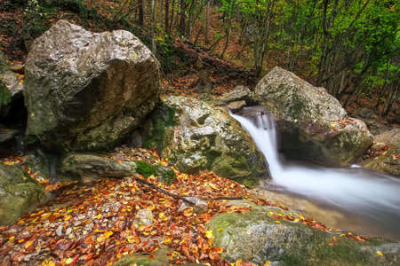Amazing Autumn landscape. River in colorful autumn park with yellow, orange, red, green leaves....