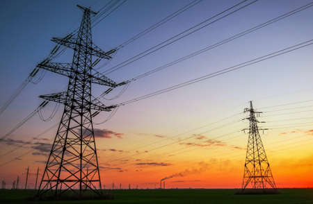 Silhouette High voltage electric towers at sunset time. High-voltage power lines. Electricity distribution stationの写真素材