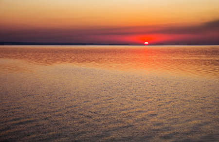 Beautiful colorful sunset on the sea coast. Nice scene with sunrise over waterの写真素材