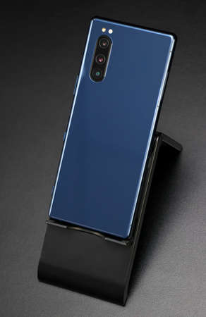 New smartphone with three cameras on the holder.の写真素材