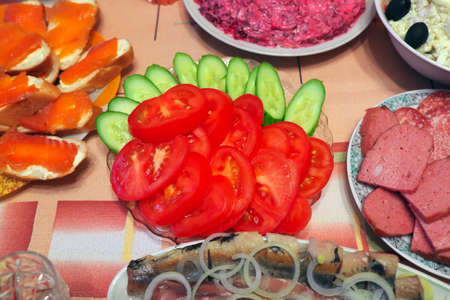 Russian homemade food. Delicious food on the table. Fish salads, vegetables, sandwiches, drinksの写真素材