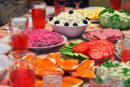 Russian homemade food. Delicious food on the table. Fish salads, vegetables, sandwiches, drinksの写真素材