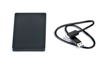 External compact SSD-drive with USB cable for writing, reading and storing data on a white...