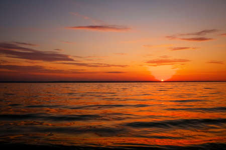 Beautiful colorful sunset on the sea coast. Nice scene with sunrise over waterの写真素材