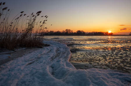Sunrise and frozen river. Beautiful winter landscape with lake in morning time. Daybreakの写真素材