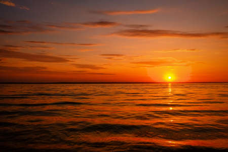 Beautiful colorful sunset on the sea coast. Nice scene with sunrise over waterの写真素材