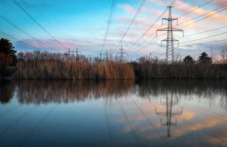 Sunset on the lake and transmission power line. の写真素材