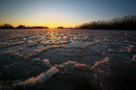 Sunrise and frozen river. Beautiful winter landscape with lake in morning time. Daybreakの写真素材