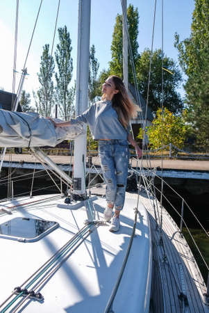 Beautiful young woman posing on yacht. Model is sailing on board.
