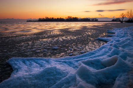 Sunrise and frozen river. Beautiful winter landscape with lake in morning time. Daybreakの写真素材