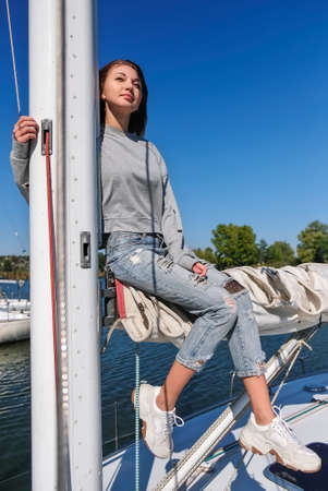 Beautiful young woman posing on yacht. Model is sailing on board.の写真素材
